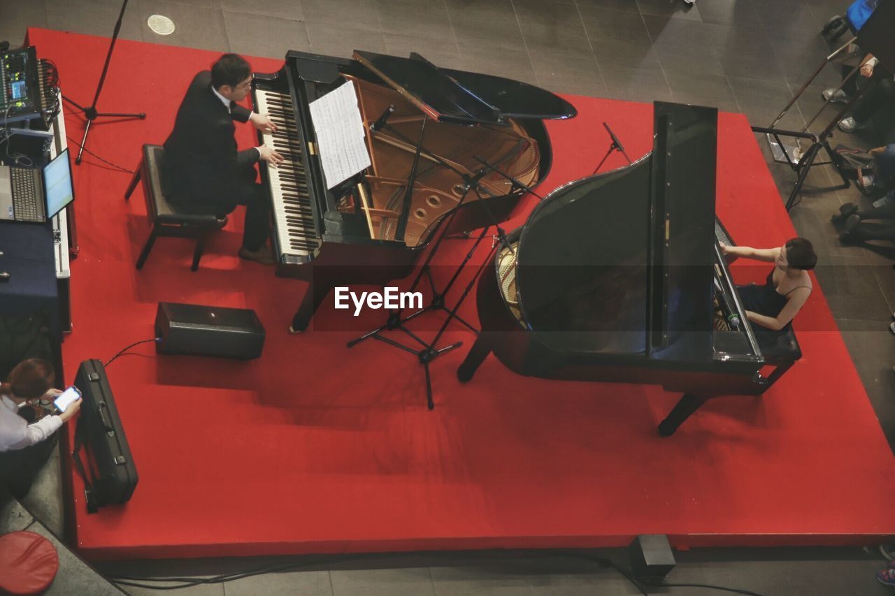 High angle view of people playing pianos during concert