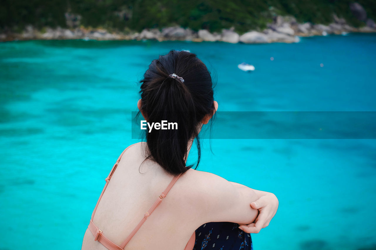 Side view of woman looking at sea