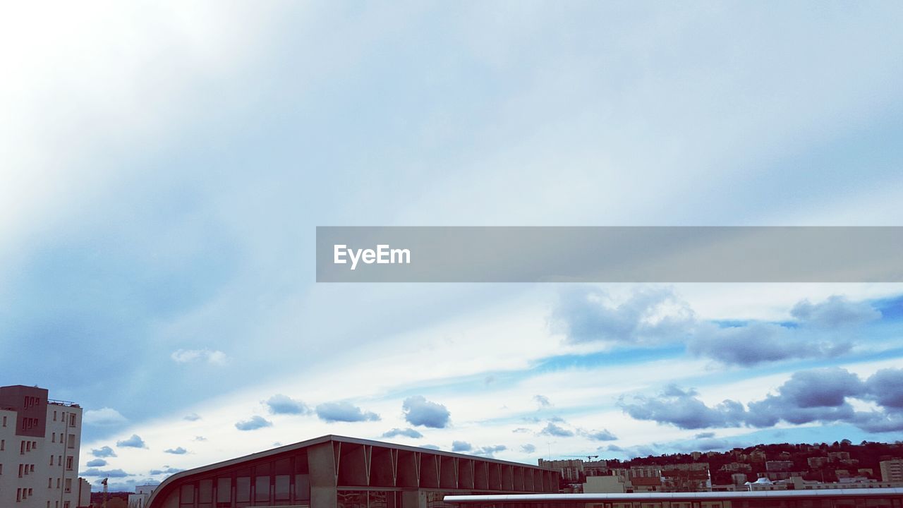 LOW ANGLE VIEW OF BUILDINGS AGAINST CLOUDY SKY