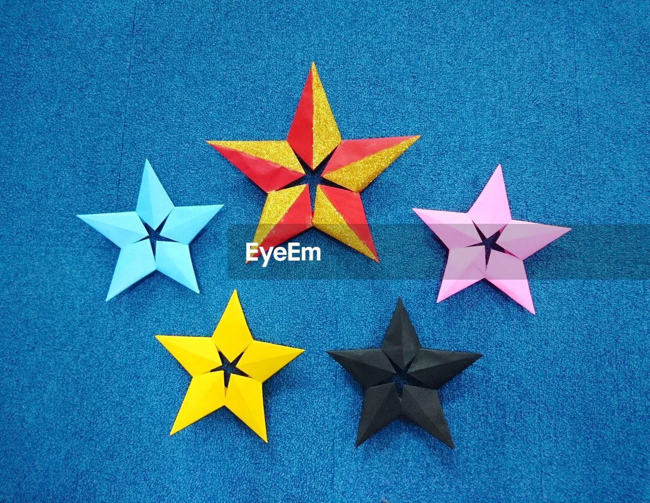 Close-up of colorful star shapes on blue wall