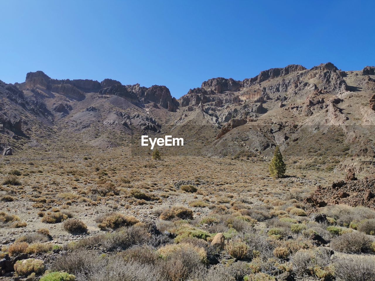 Scenic view of rocky mountains against clear blue sky