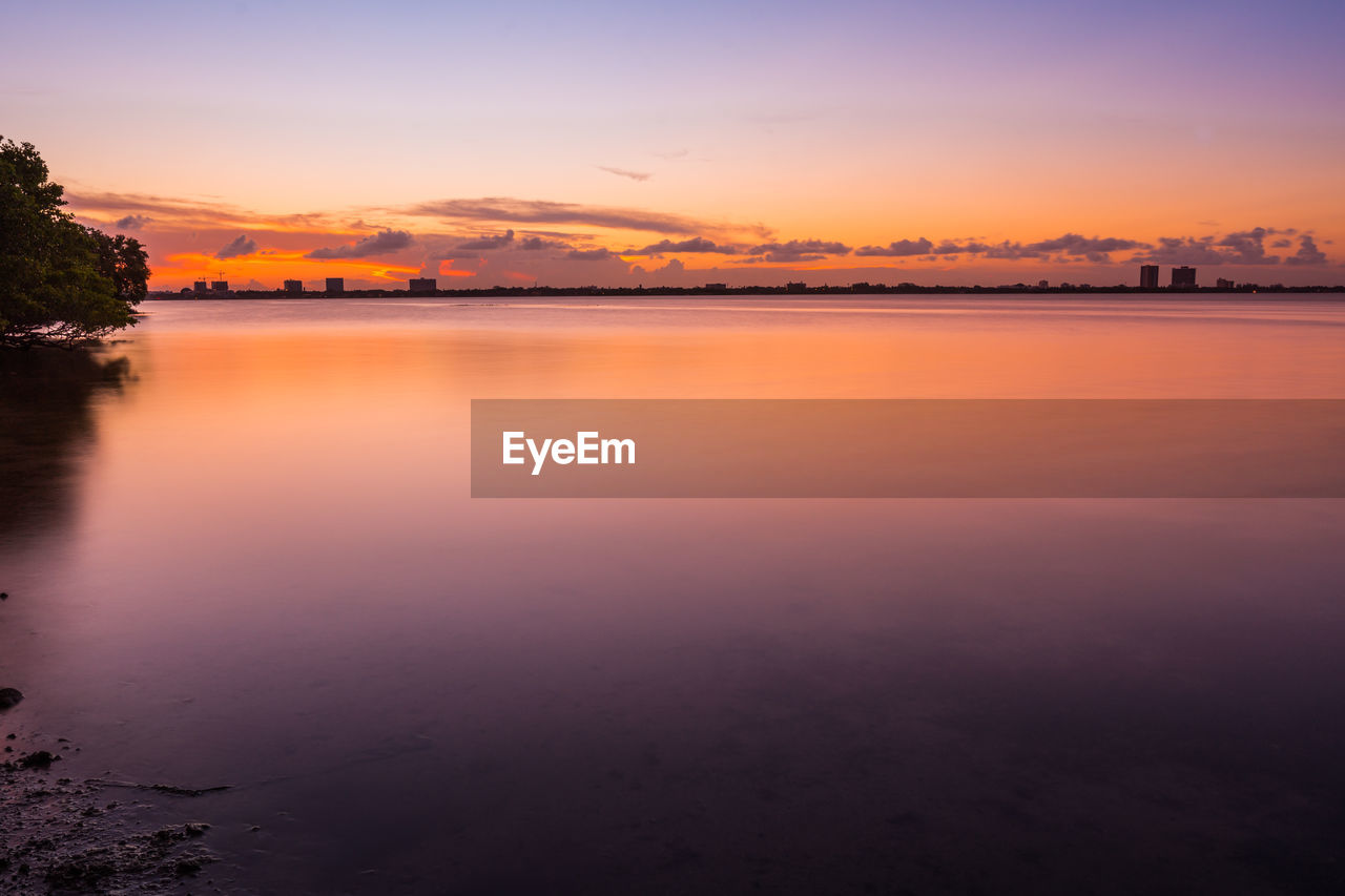 SCENIC VIEW OF LAKE AGAINST SKY DURING SUNSET