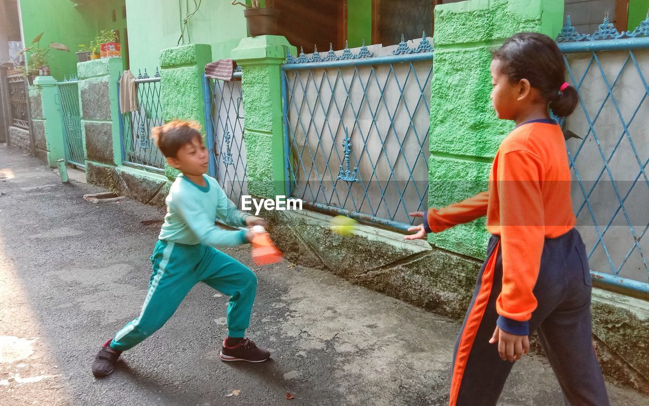 FULL LENGTH OF A GIRL PLAYING WITH BABY IN PARK