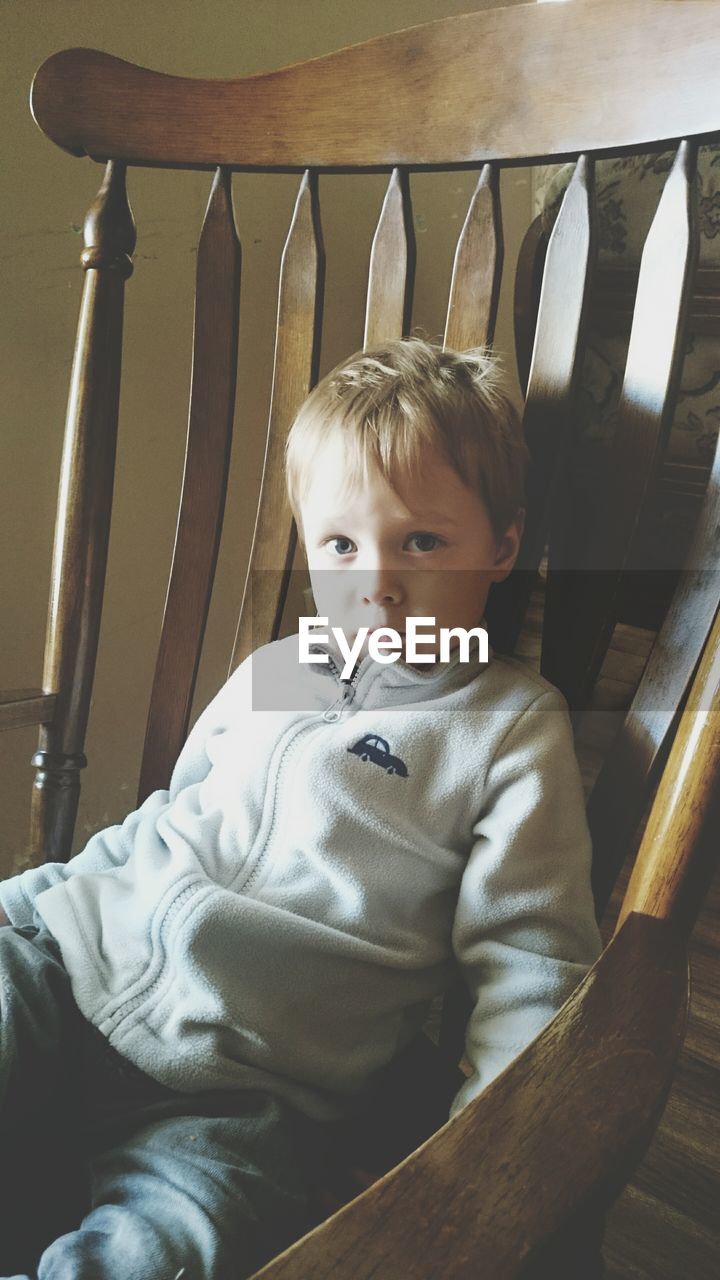 Portrait of cute boy sitting on chair