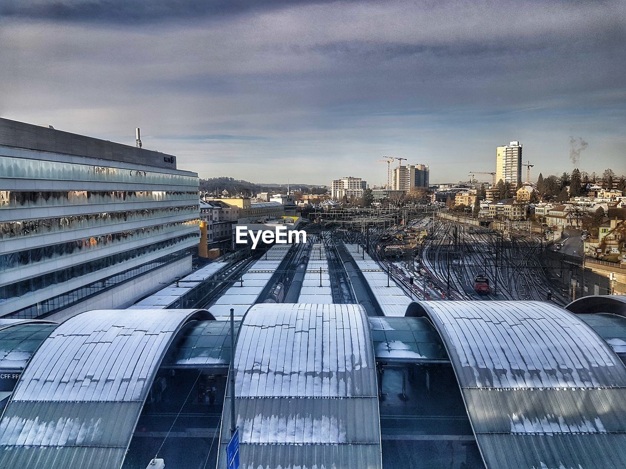 RAILROAD TRACKS BY BUILDINGS AGAINST SKY IN CITY