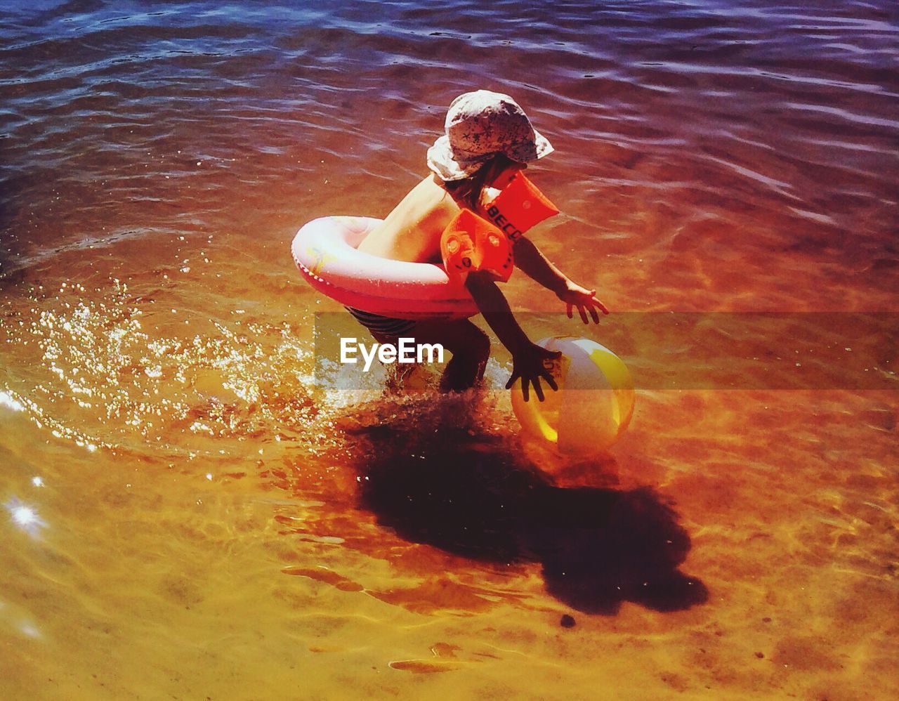 High angle view of girl playing with ball in sea