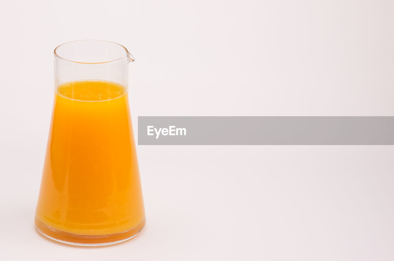 Glass of bottle against white background