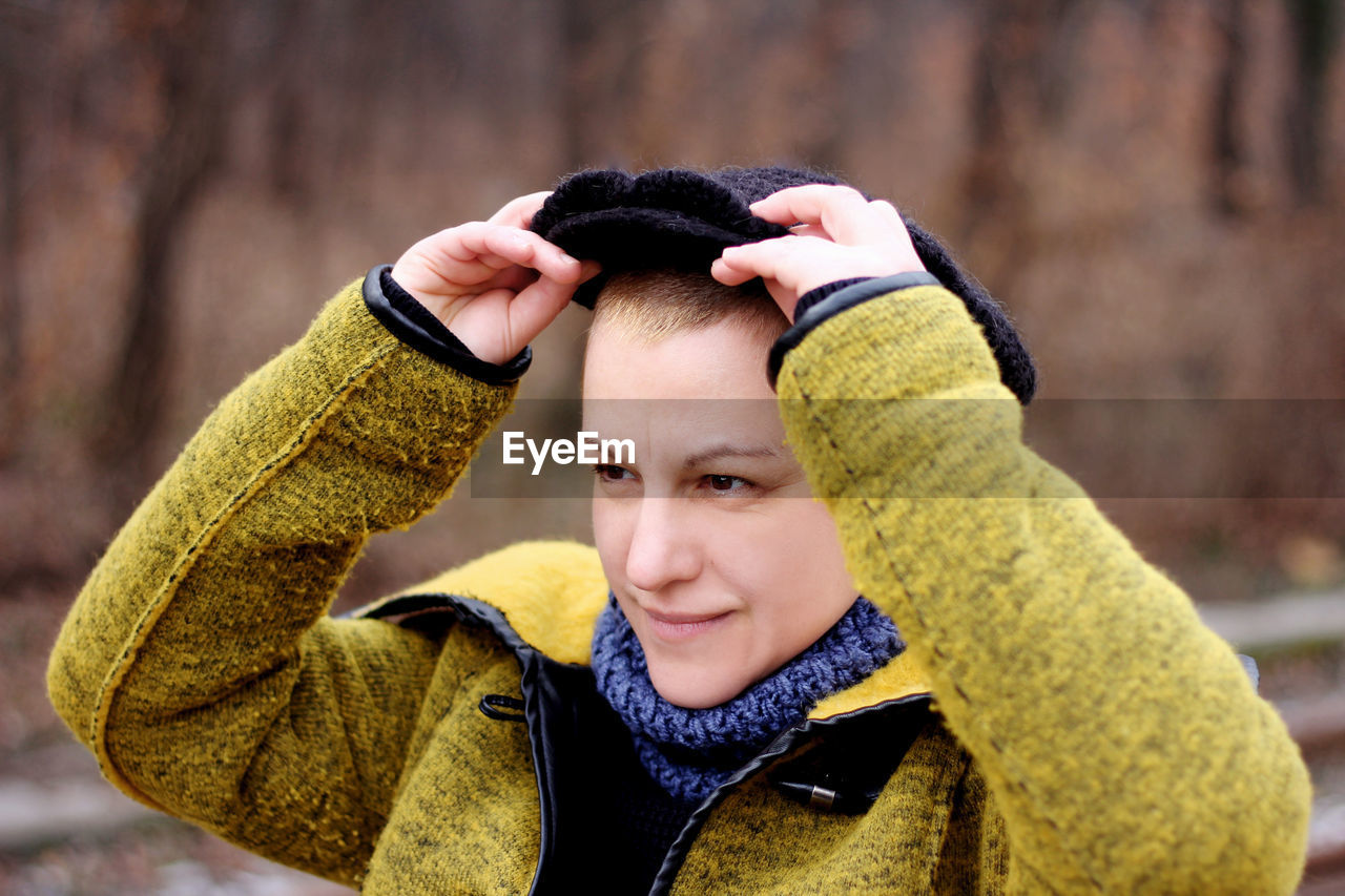 Smiling woman looking away wearing hat during winter