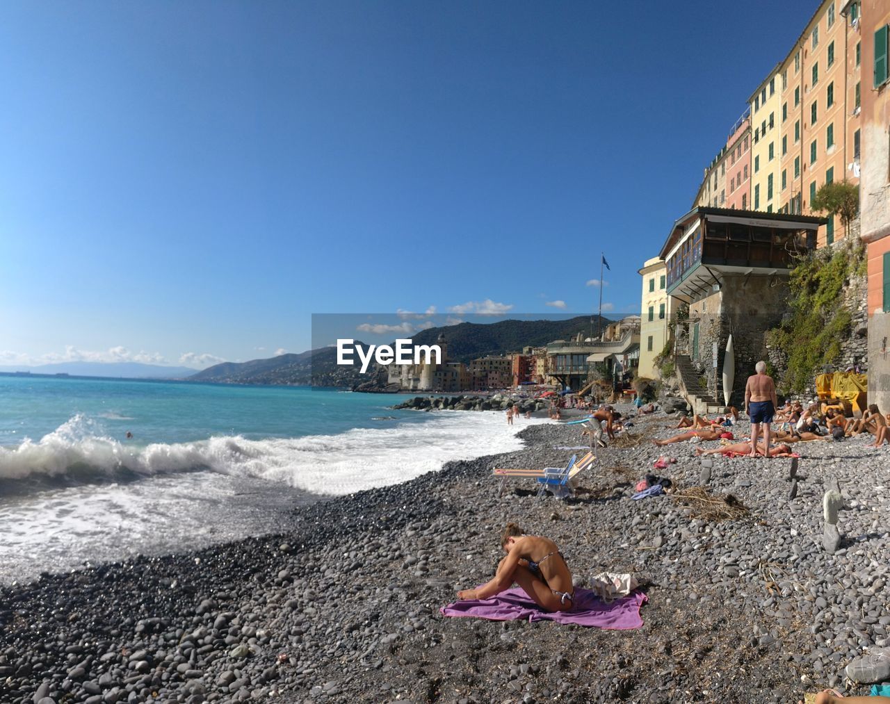 People relaxing at beach against sky