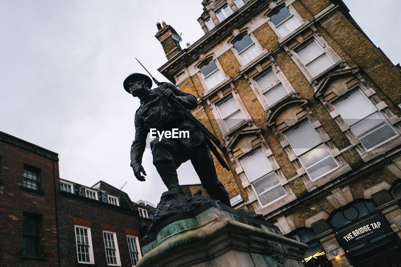 Low angle view of statue against building in city