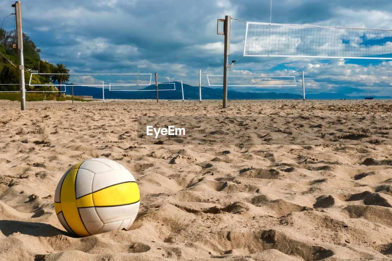 CLOSE-UP OF YELLOW BALL ON BEACH