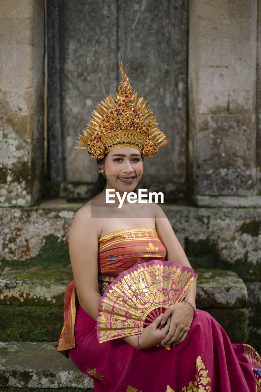 Portrait of young woman wearing traditional clothing sitting on steps