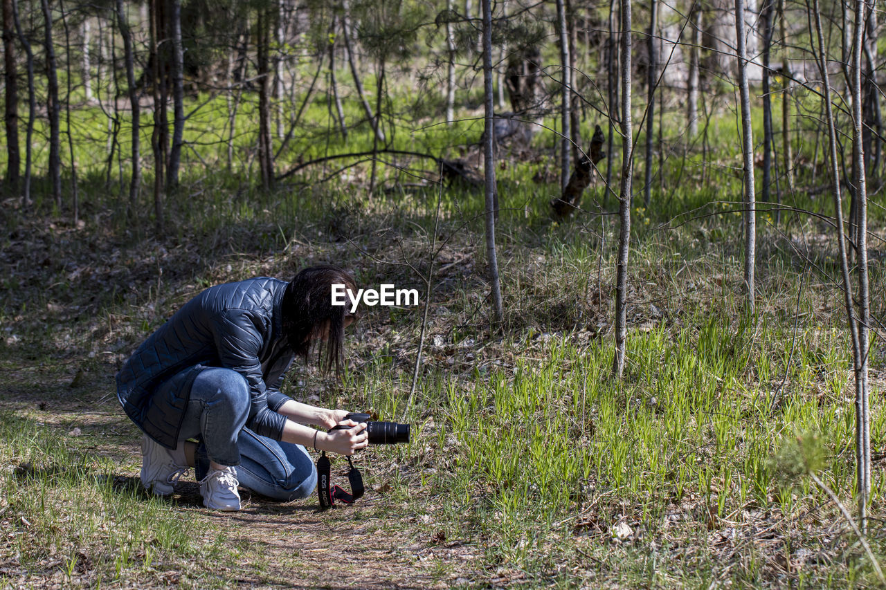 MAN PHOTOGRAPHING THROUGH CAMERA ON LAND