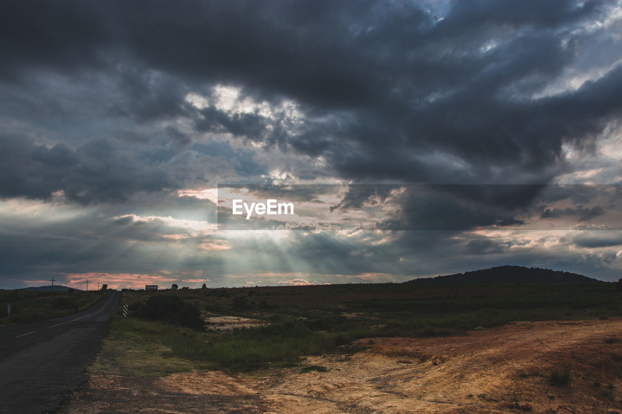 Scenic view of field against cloudy sky