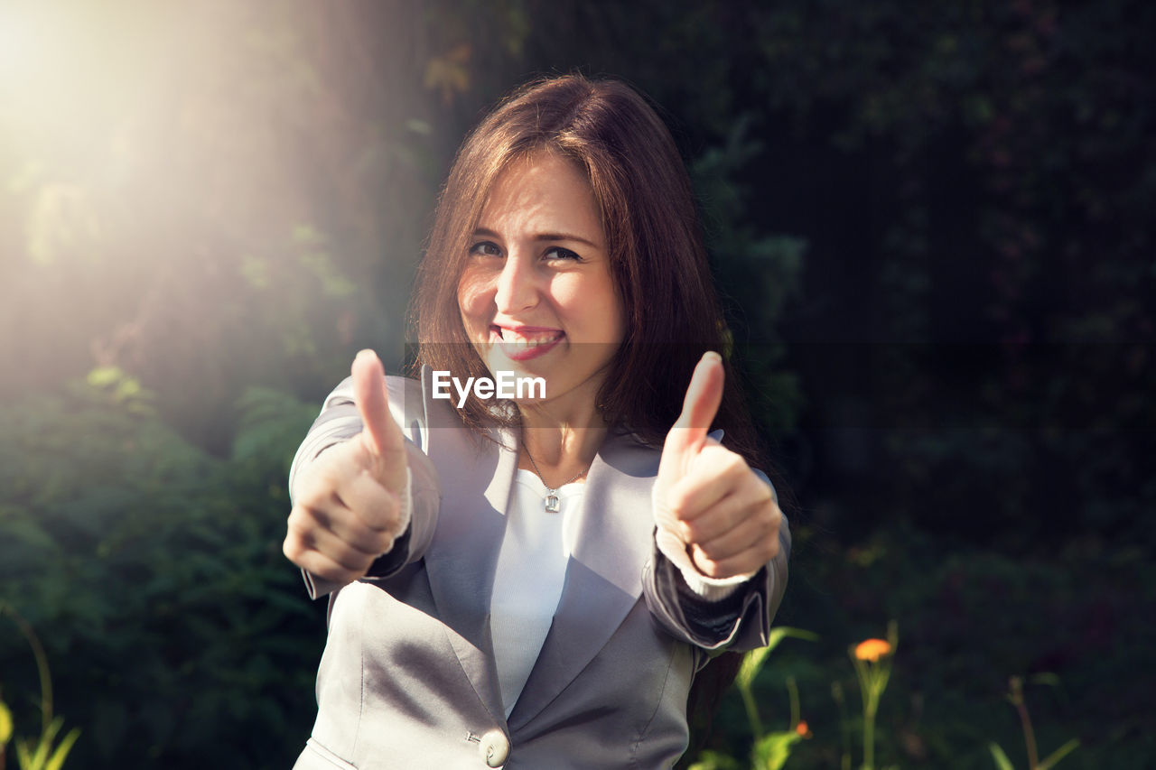 Portrait of smiling businesswoman showing thumbs up sign