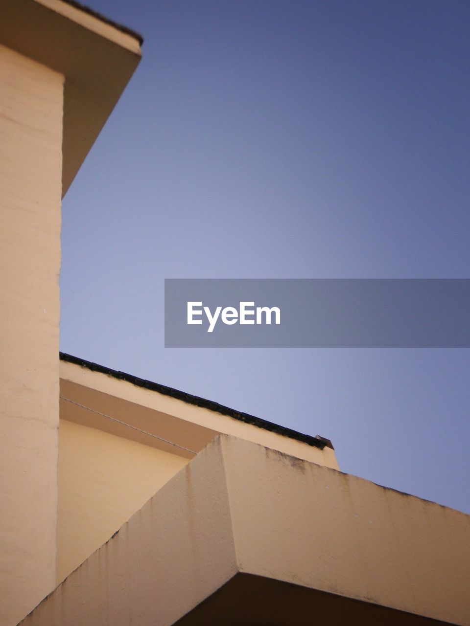 LOW ANGLE VIEW OF BUILDING AGAINST BLUE SKY