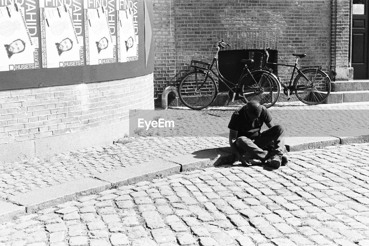 FULL LENGTH OF MAN SITTING ON BICYCLE