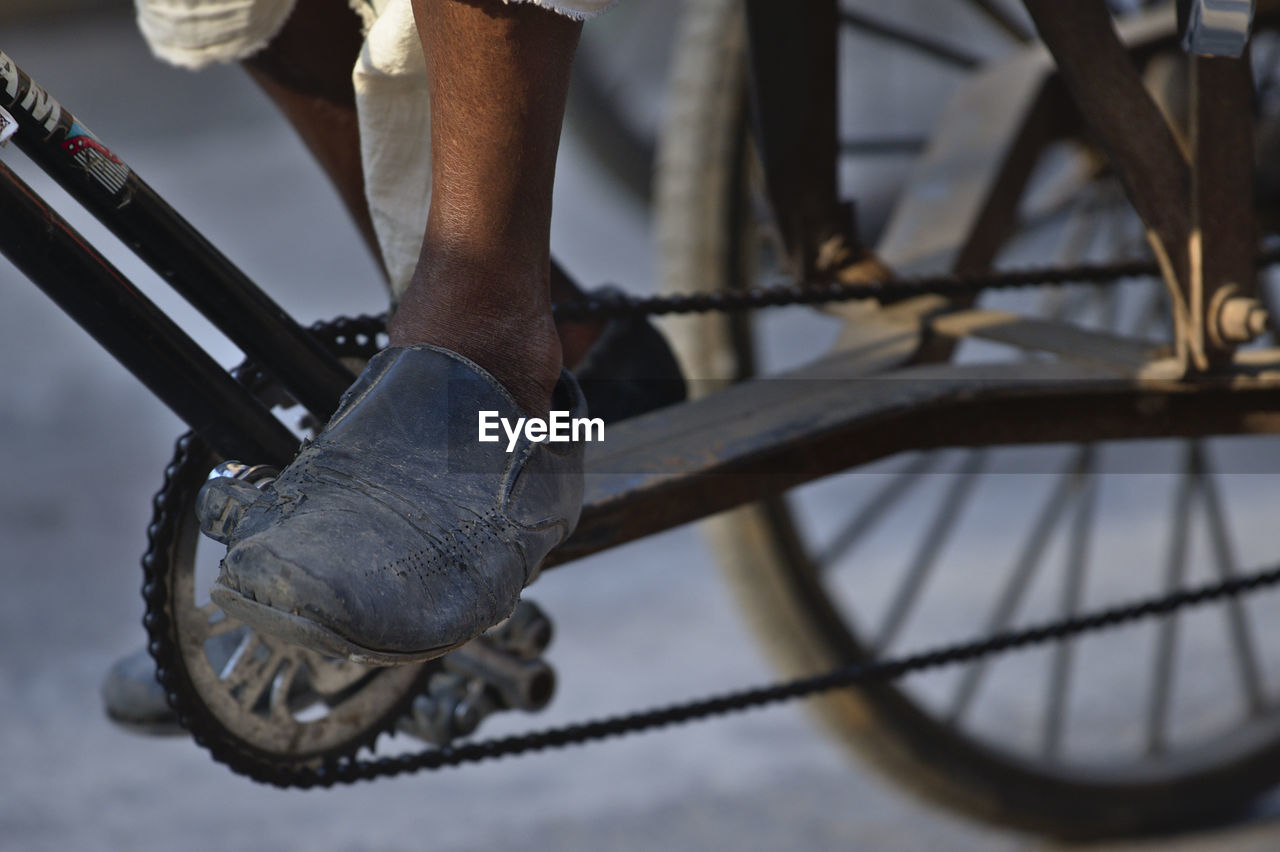 Low section of man standing on bicycle