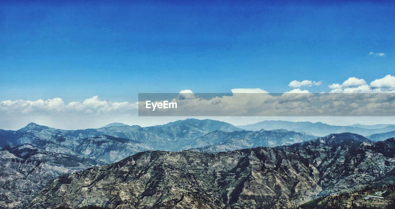 Scenic view of mountains against blue sky