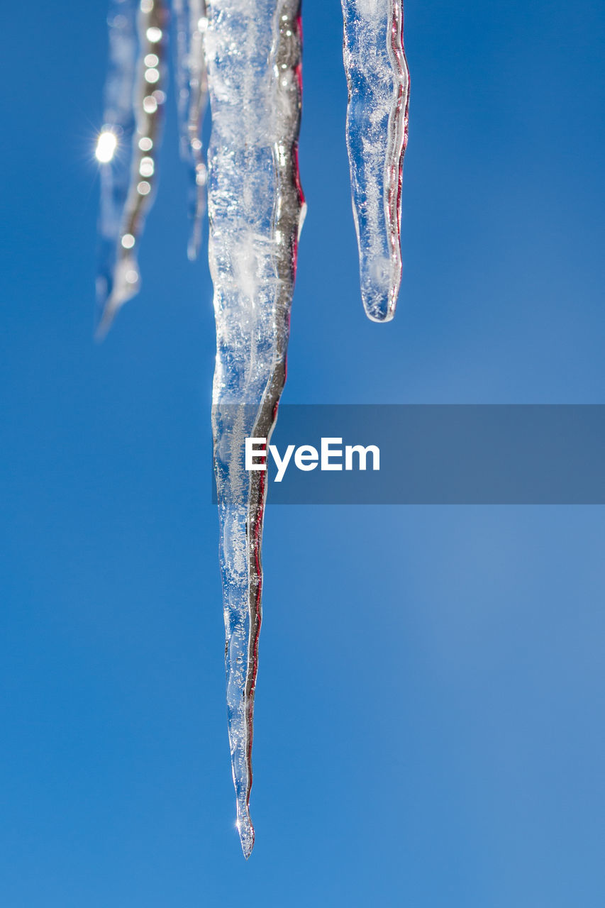 Close-up of ice crystals against blue sky