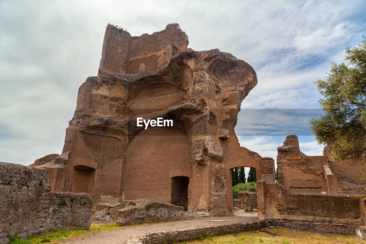 ruins, architecture, ancient history, history, the past, travel destinations, rock, ancient, historic site, travel, cloud, built structure, sky, temple, old ruin, building, nature, archaeological site, fortification, religion, tourism, temple - building, old, ancient civilization, no people, landscape, place of worship, outdoors, stone material, building exterior, arch, landmark, environment, archaeology, brick, business finance and industry, belief, land, plant