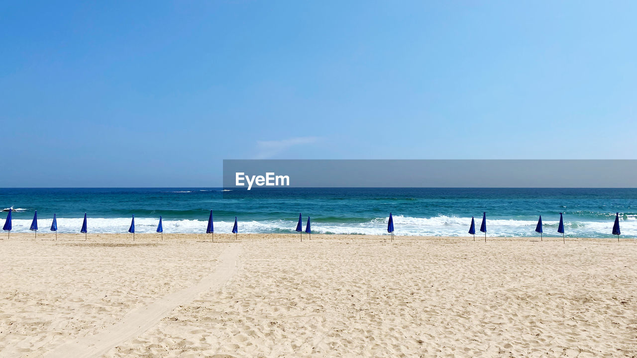 Scenic view of beach against blue sky