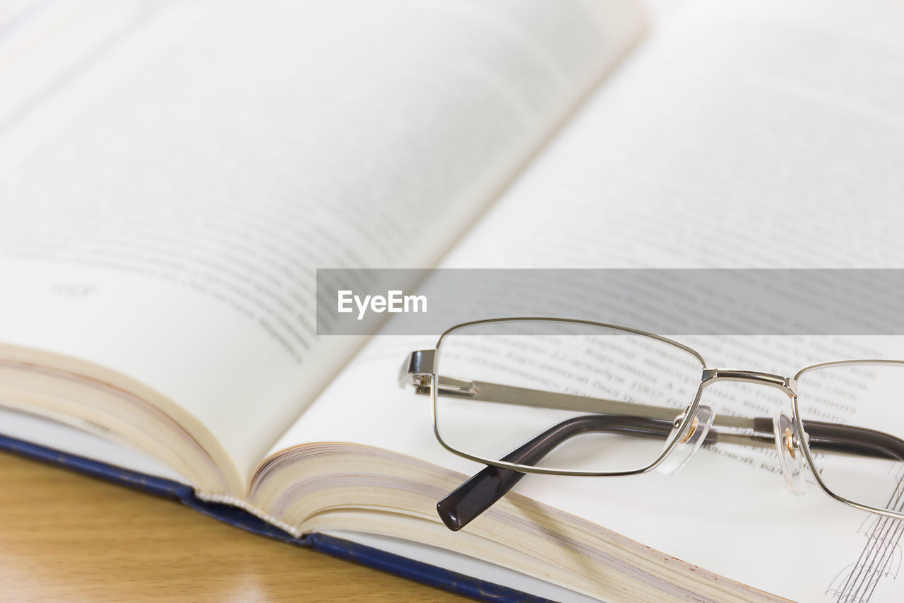 High angle view of eyeglasses and book on table