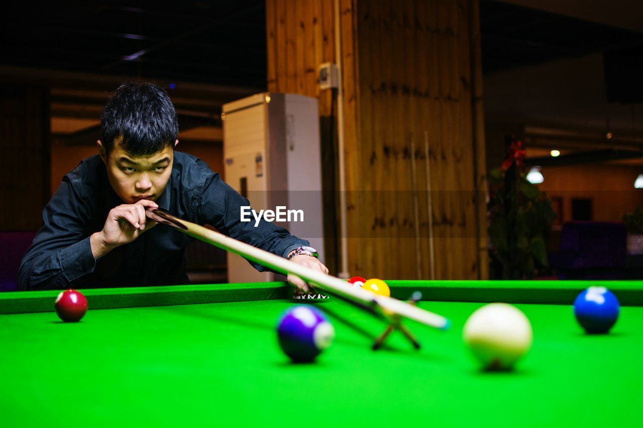 YOUNG WOMAN PLAYING WITH BALL IN POOL