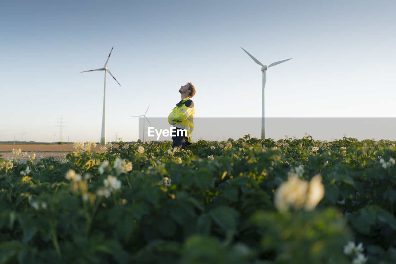 Engineer standing in a field at a wind farm