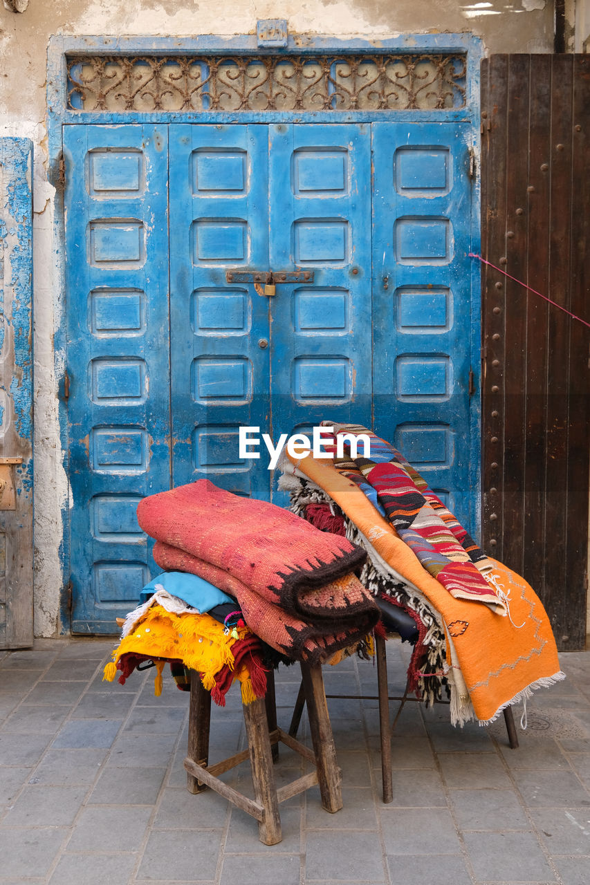 Multi colored carpets  against blue wooden door