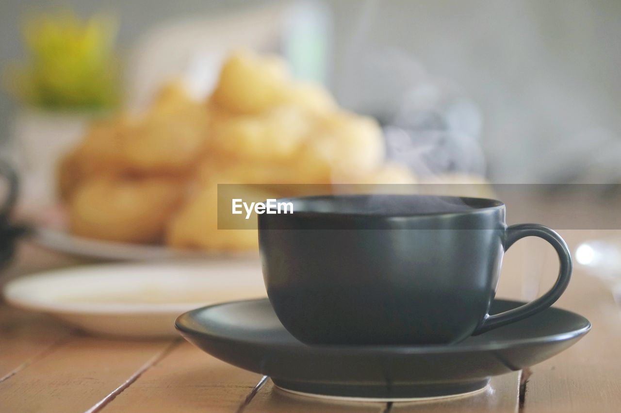 CLOSE-UP OF COFFEE CUP ON TABLE IN CAFE