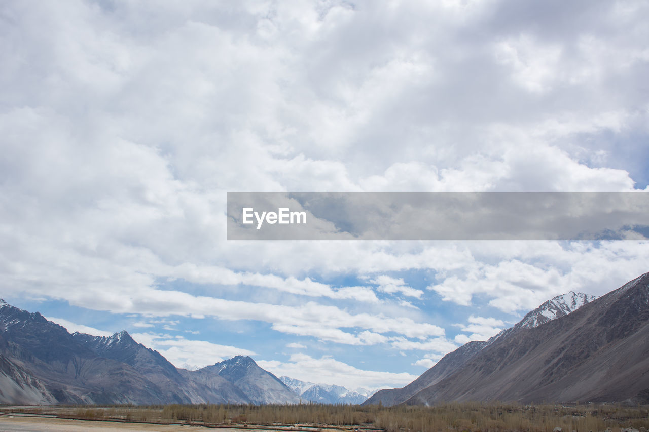 Scenic view of mountains against cloudy sky