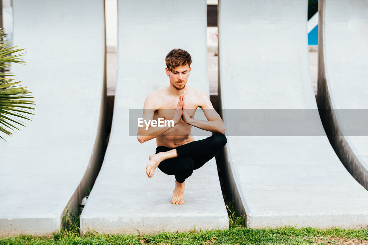 Portrait of shirtless young man looking at camera