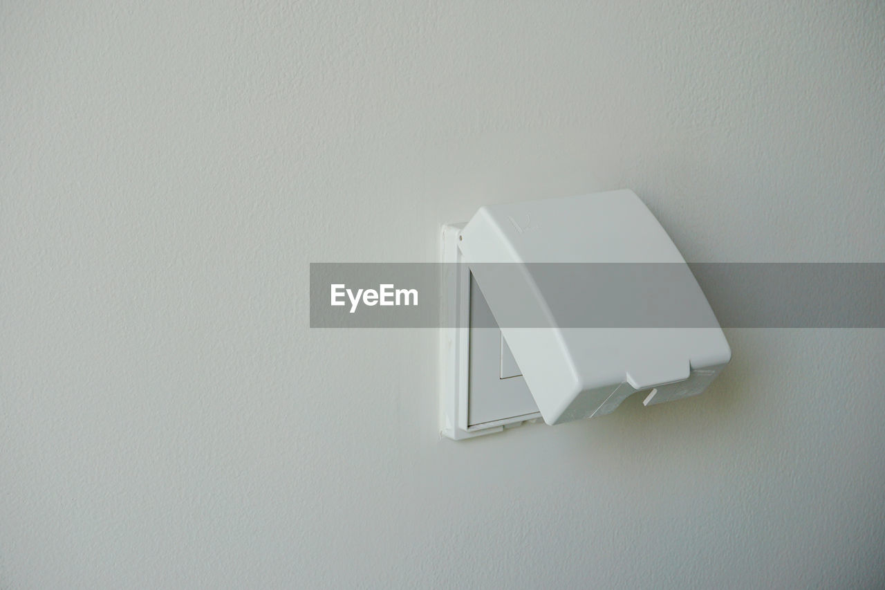 HIGH ANGLE VIEW OF WHITE WALL AND ELECTRIC LIGHT ON FLOOR