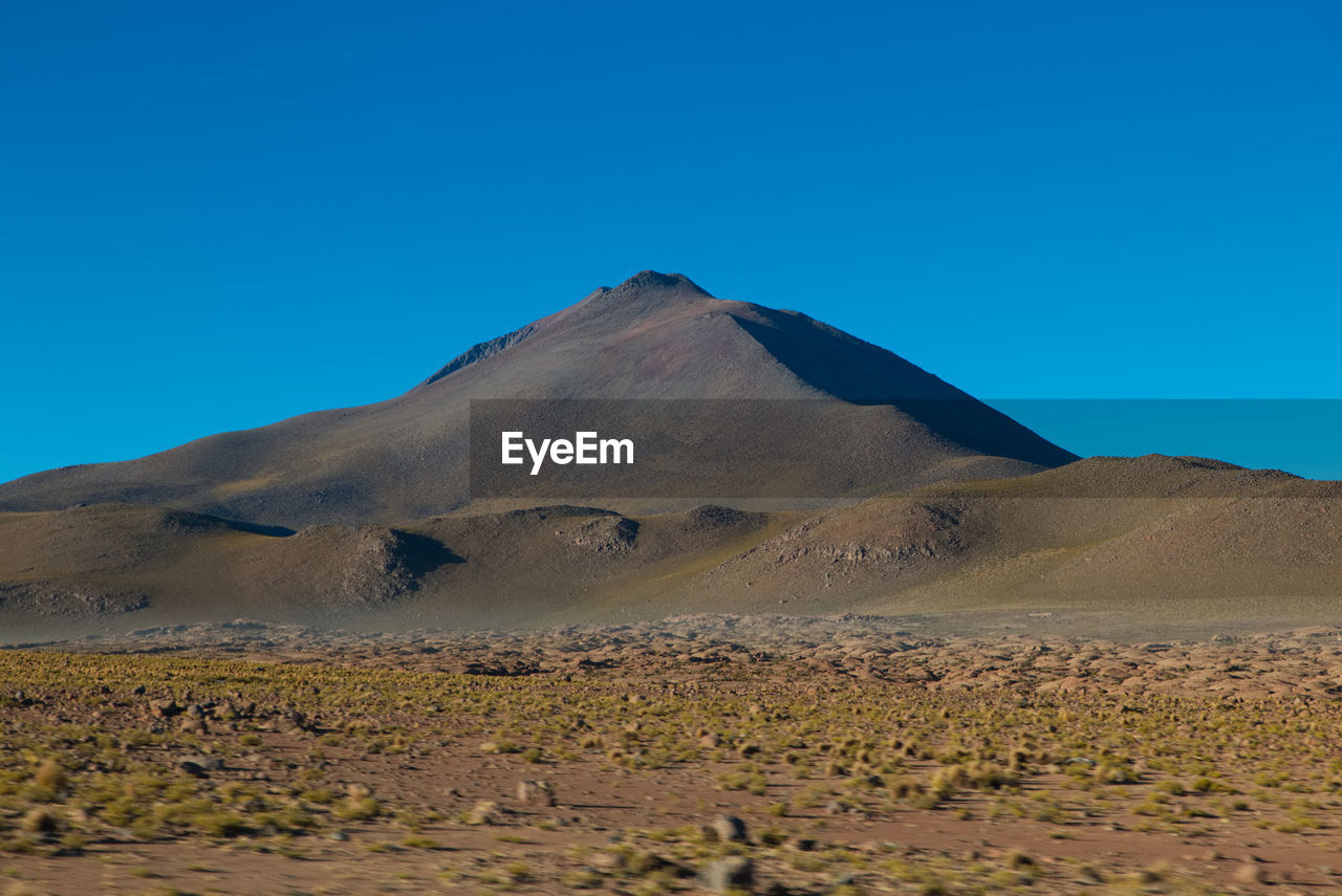 SCENIC VIEW OF VOLCANIC LANDSCAPE AGAINST BLUE SKY