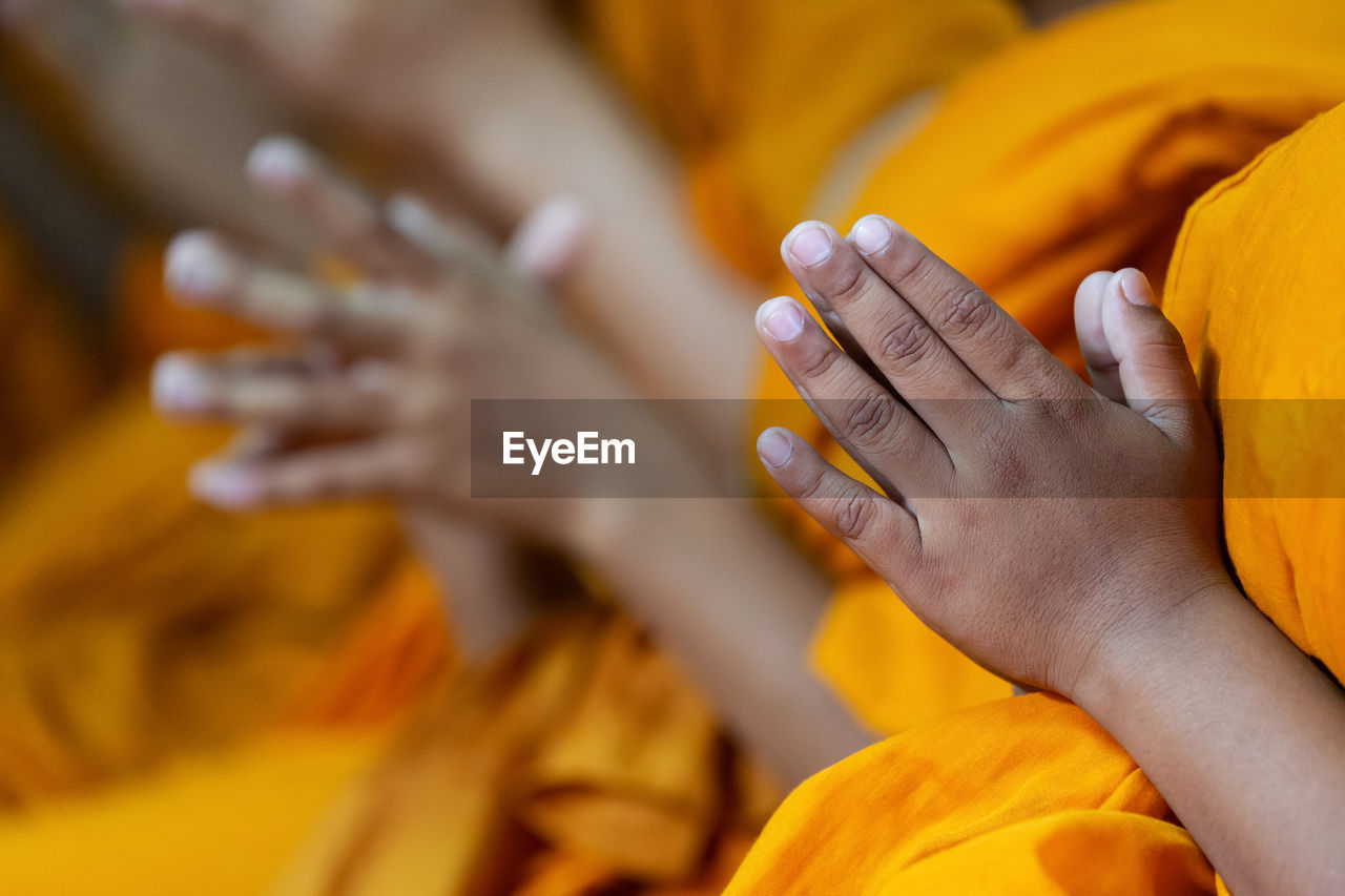 Midsection of monks praying at temple