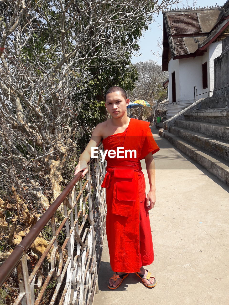 Full length of young man standing against trees