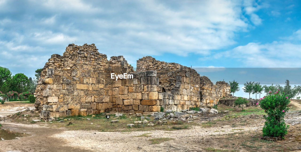 VIEW OF STONE WALL AGAINST TREES