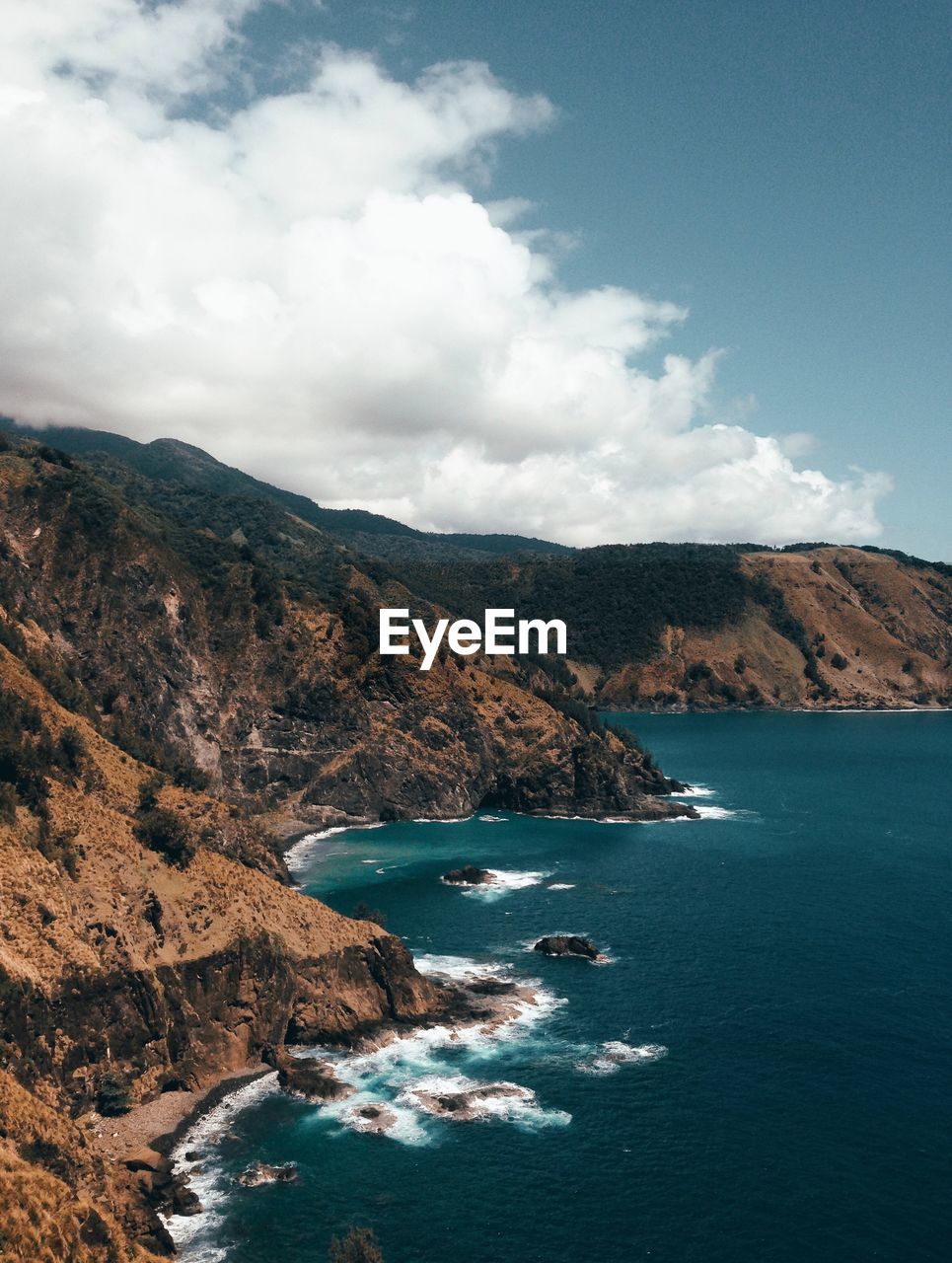 Scenic view of sea by mountains against sky