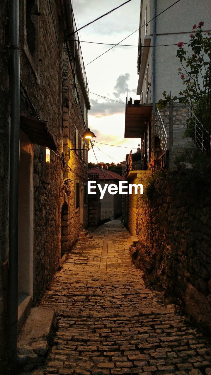 NARROW FOOTPATH AMIDST BUILDINGS IN TOWN