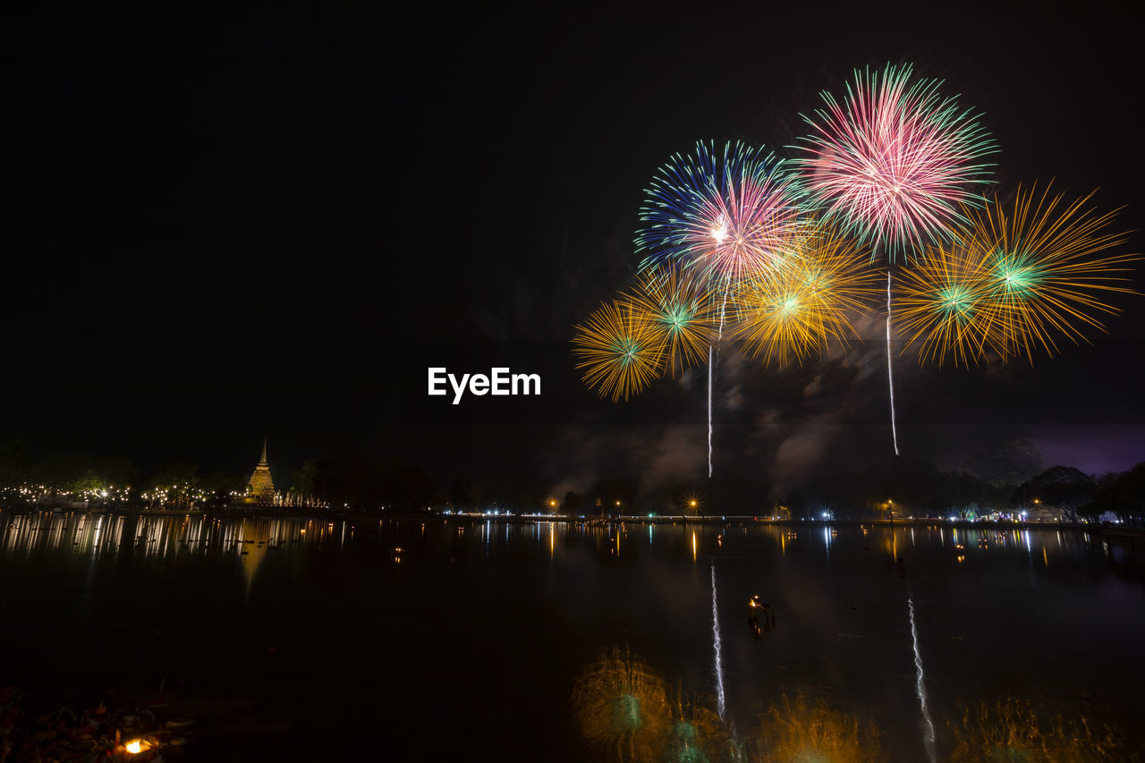 FIREWORK DISPLAY OVER RIVER AGAINST SKY