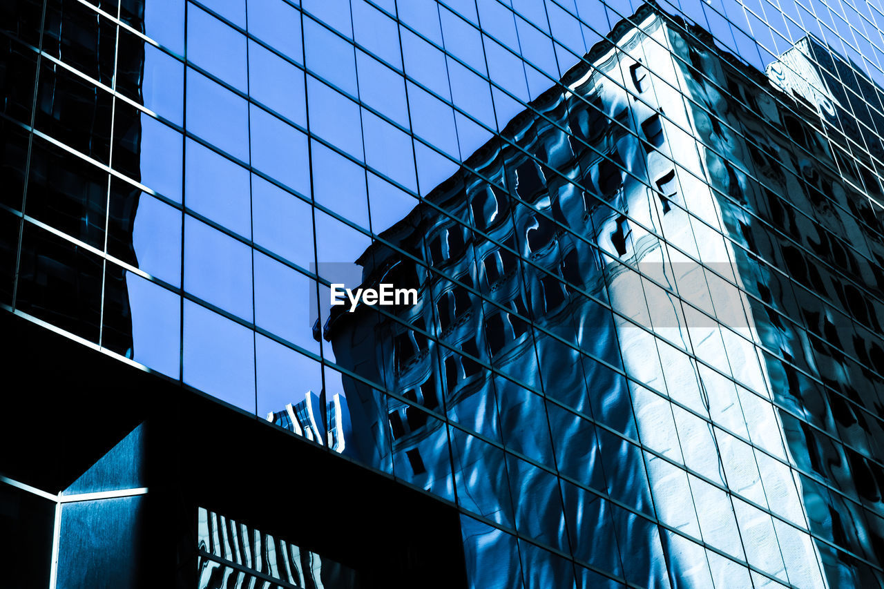 Low angle view of office building with reflection