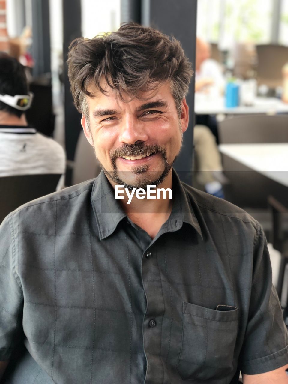 Portrait of smiling man sitting at restaurant