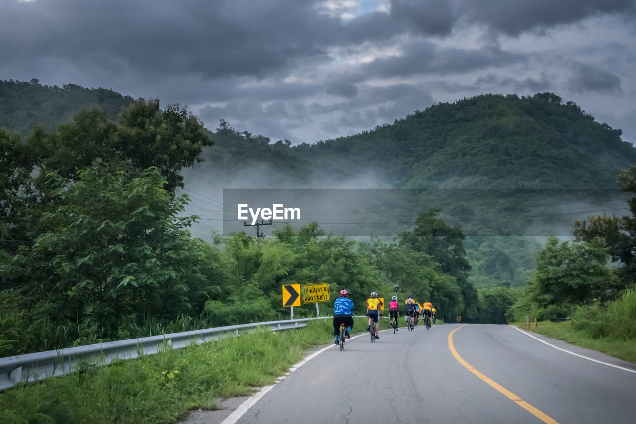 Rear view of people on road against sky