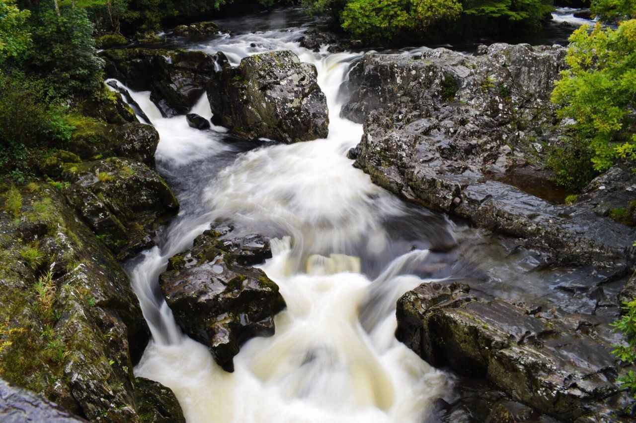 RIVER FLOWING THROUGH ROCKS IN FOREST