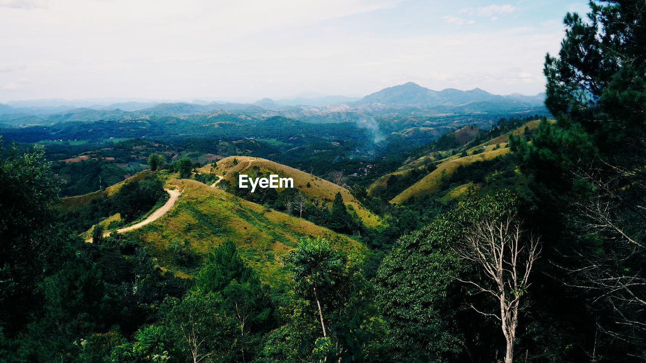 Aerial view of green landscape and mountains against sky