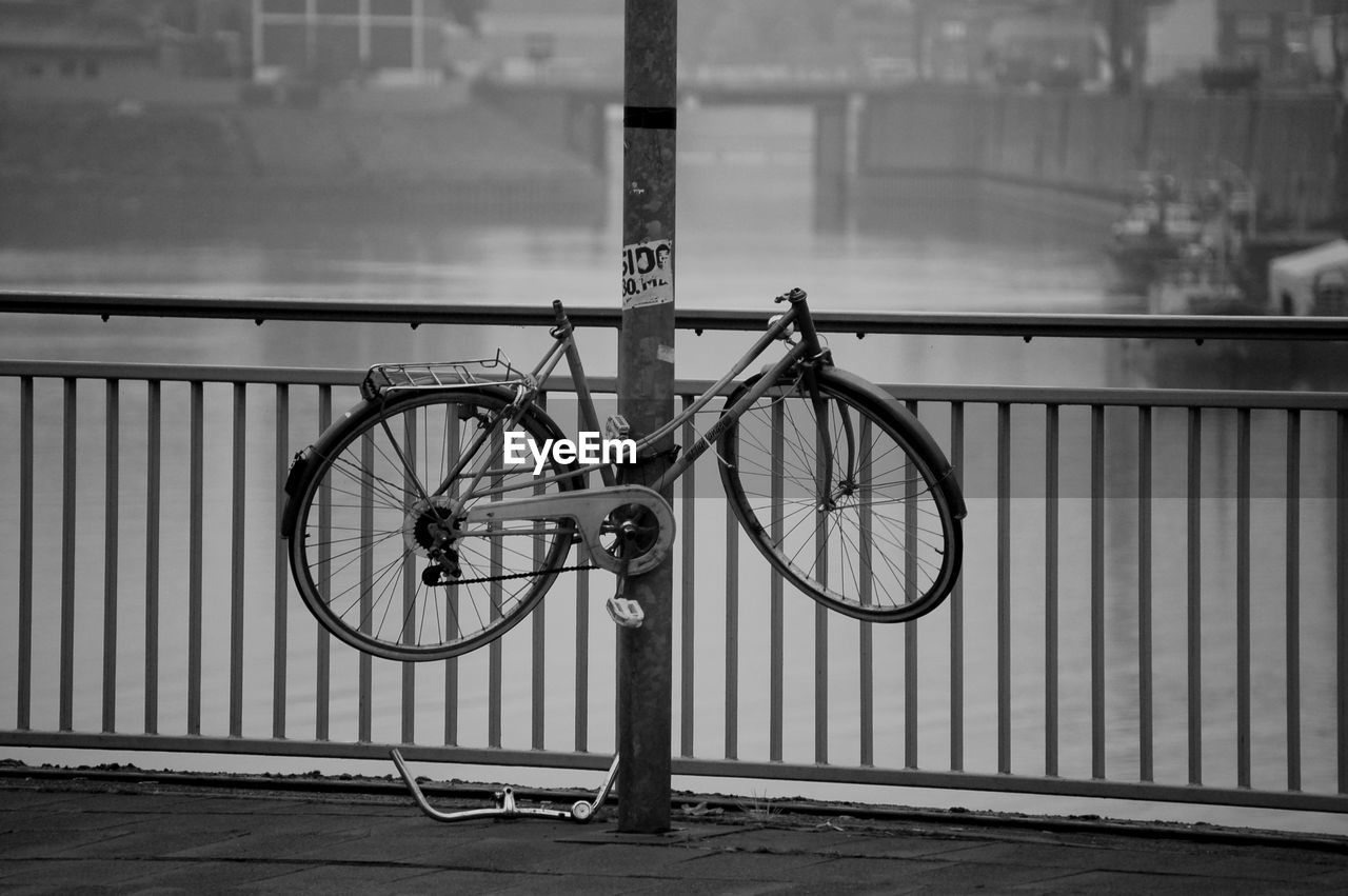 Broken bicycle tied to pole