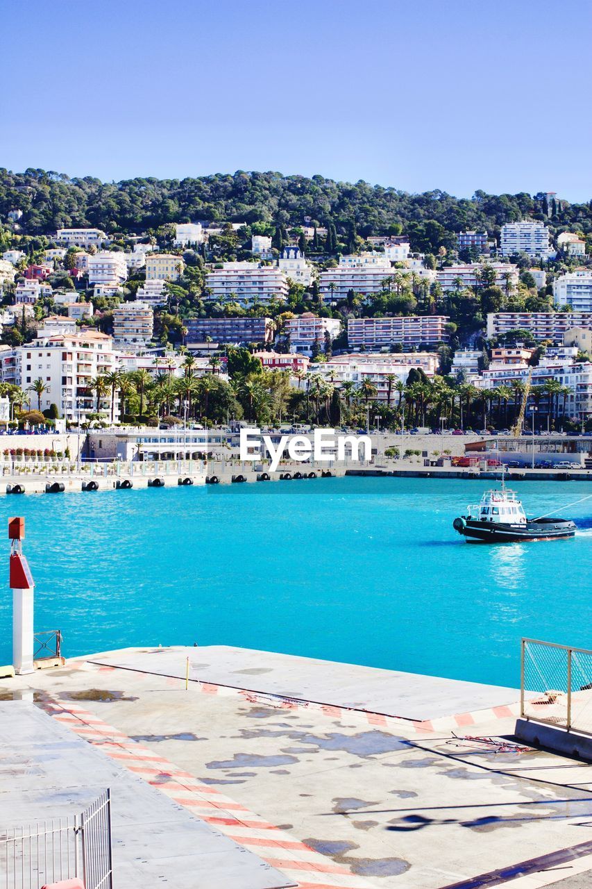 SCENIC VIEW OF SEA BY CITY AGAINST CLEAR SKY