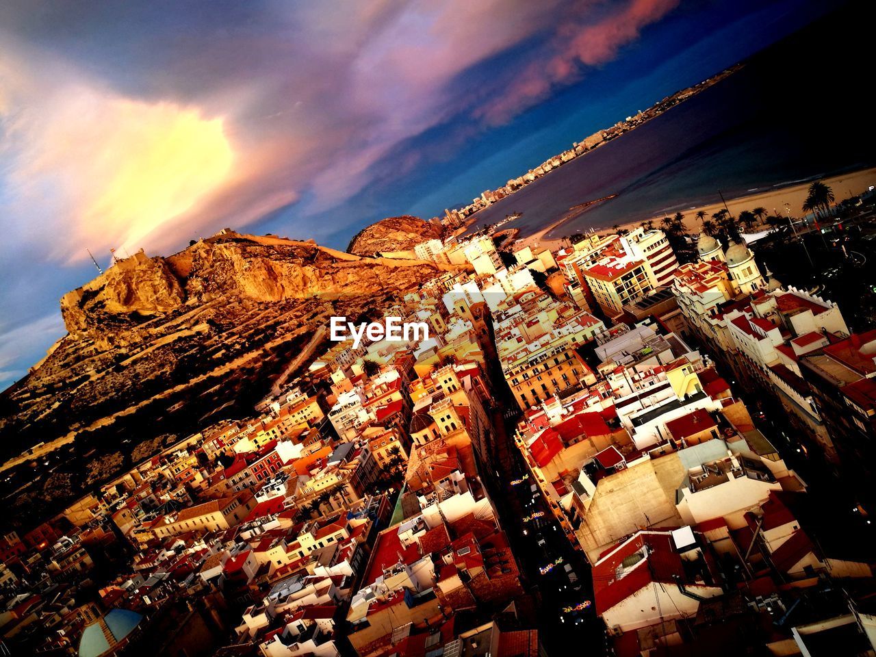 VIEW OF CITYSCAPE AGAINST CLOUDY SKY