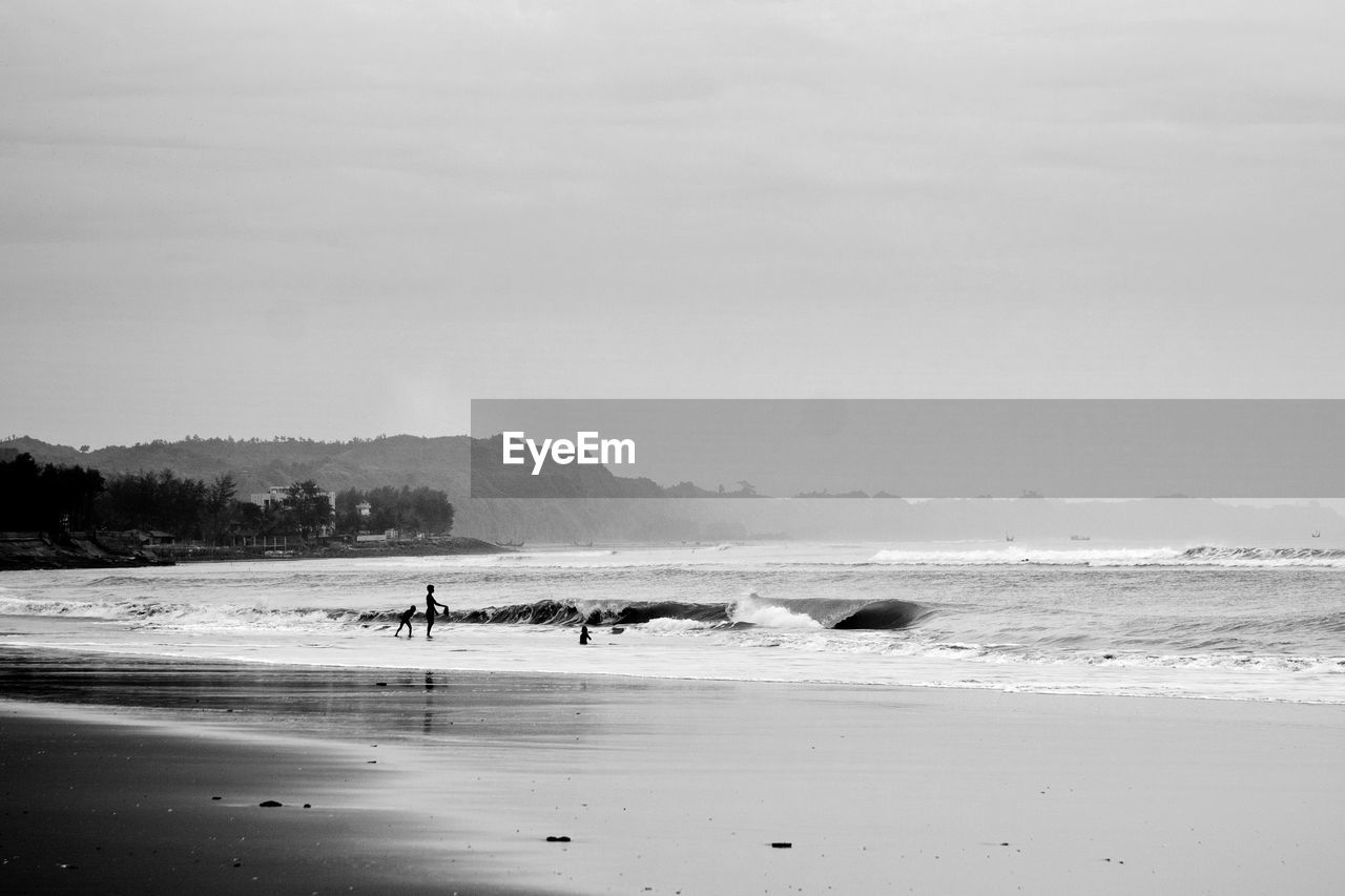 People on beach against sky